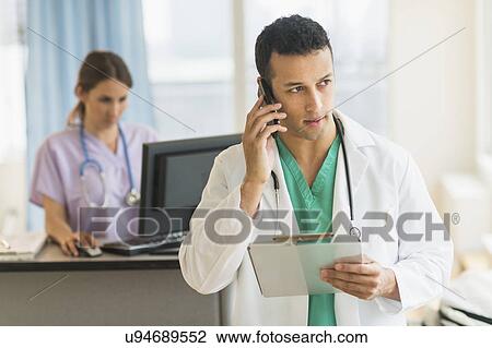 Male and female nurses working at nurse's station in hospital View Large Photo Image Stock Image - Male and female nurses working at nurse's station in hospital. Fotosearch