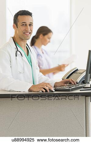 Male and female nurses working at nurse's station in hospital View Large Photo Image Stock Photography - Male and female nurses working at nurse's station in hospital. Fotosearch