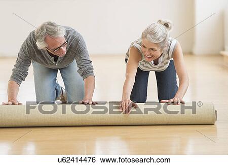 Man and woman rolling carpet View Large Photo Image Stock Photograph - Man and woman rolling carpet. Fotosearch