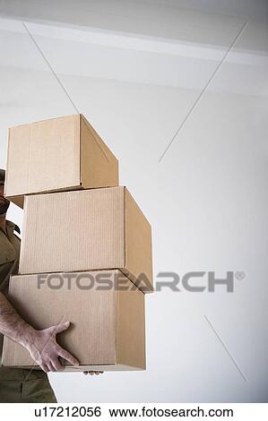 Man carrying stack of boxes View Large Photo Image Stock Photograph - Man carrying stack of boxes. Fotosearch