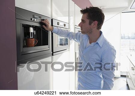 Man making coffee in kitchen View Large Photo Image Stock Image - Man making coffee in kitchen. Fotosearch