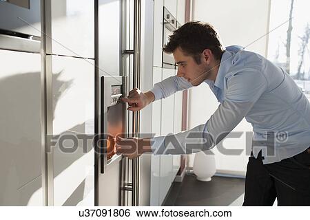 Man making coffee in kitchen View Large Photo Image Stock Photograph - Man making coffee in kitchen. Fotosearch