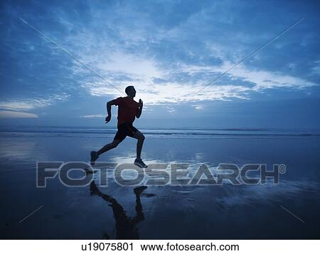 Man running along beach View Large Photo Image Stock Image - Man running along beach. Fotosearch