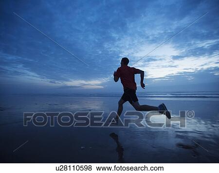 Man running along beach View Large Photo Image Stock Photo - Man running along beach. Fotosearch