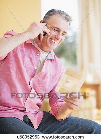 Man sitting and using mobile phone View Large Photo Image Stock Image - Man sitting and using mobile phone. Fotosearch