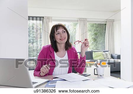 Stock Photograph - Mature businesswoman doing paperwork. Fotosearch