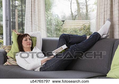 Stock Photo - Mature woman relaxing on sofa. Fotosearch