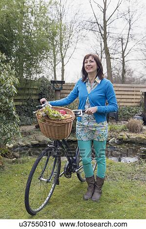 Mature woman with fresh vegetables in bike basket View Large Photo Image Stock Image - Mature woman with fresh vegetables in bike basket. Fotosearch