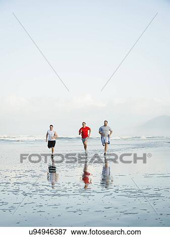 Men running on beach View Large Photo Image Stock Photo - Men running on beach. Fotosearch
