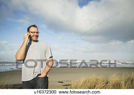 Stock Image - Mid adult man taking photograph. Fotosearch