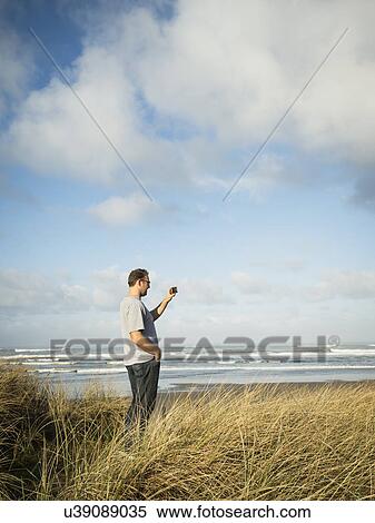 Stock Photography - Mid adult man taking photograph. Fotosearch