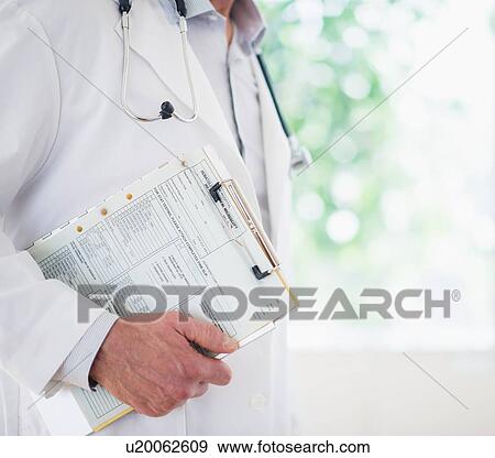 Mid section of doctor holding medical record View Large Photo Image Stock Photo - Mid section of doctor holding medical record. Fotosearch