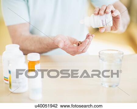 Mid section of man taking medicine View Large Photo Image Stock Image - Mid section of man taking medicine. Fotosearch