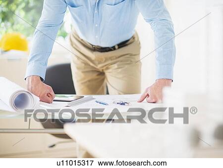 Mid section of man working in office View Large Photo Image Stock Photo - Mid section of man working in office. Fotosearch