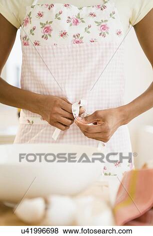 Mid section of woman tying her apron View Large Photo Image Stock Photo - Mid section of woman tying her apron. Fotosearch