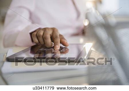 Stock Photo - Mid section of woman using digital tablet. Fotosearch