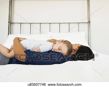Stock Photograph - Mother and son (2-5 months) sleeping together. Fotosearch