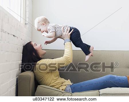 Mother holding up her daughter (12-17 months) View Large Photo Image Stock Image - Mother holding up her daughter (12-17 months) . Fotosearch