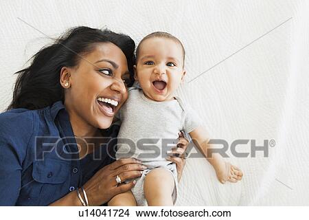 Mother with baby boy (2-5 months) hugging and laughing View Large Photo Image Picture - Mother with baby boy (2-5 months) hugging and laughing. Fotosearch