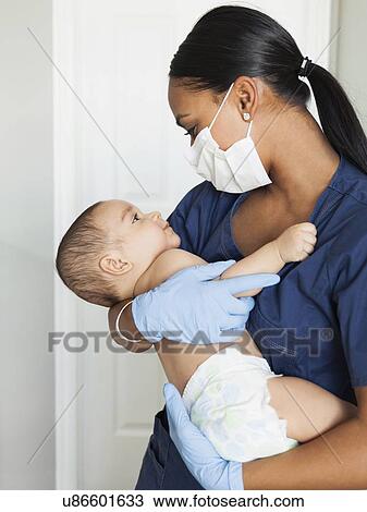 Nurse holding in arms baby boy (2-5 months) View Large Photo Image Stock Image - Nurse holding in arms baby boy (2-5 months). Fotosearch