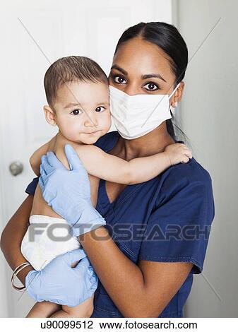 Nurse holding in arms baby boy (2-5 months) View Large Photo Image Stock Image - Nurse holding in arms baby boy (2-5 months). Fotosearch