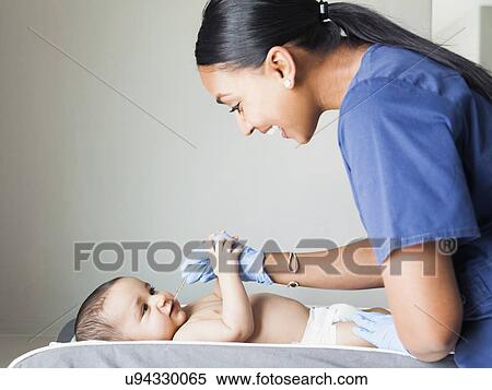 Nurse playing with ill baby boy (2-5 months) View Large Photo Image Stock Photography - Nurse playing with ill baby boy (2-5 months). Fotosearch