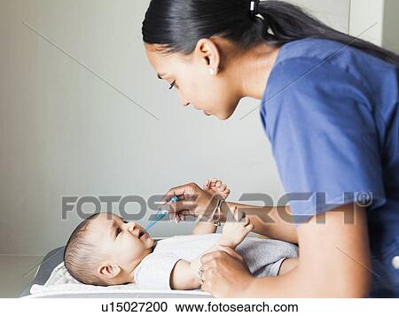Nurse taking baby boy's (2-5 months) temperature View Large Photo Image Stock Image - Nurse taking baby boy's (2-5 months) temperature. Fotosearch