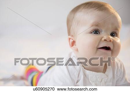 Portrait of baby girl (6-11 months) lying on bed View Large Photo Image Stock Image - Portrait of baby girl (6-11 months) lying on bed. Fotosearch
