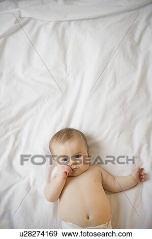 Portrait of baby girl (6-11 months) lying down View Large Photo Image Stock Photo - Portrait of baby girl (6-11 months) lying down. Fotosearch