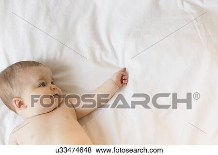 Portrait of baby girl (6-11 months) lying down View Large Photo Image Stock Photo - Portrait of baby girl (6-11 months) lying down. Fotosearch