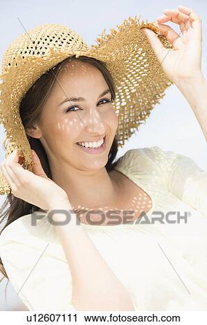 Stock Image - Portrait of beautiful young woman in sun hut. Fotosearch