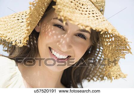 Stock Image - Portrait of beautiful young woman in sun hut. Fotosearch