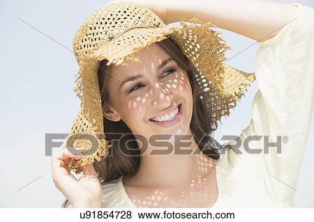 Stock Photo - Portrait of beautiful young woman in sun hut. Fotosearch