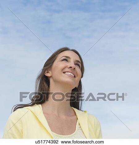 Portrait of beautiful young woman against sky View Large Photo Image Stock Image - Portrait of beautiful young woman against sky. Fotosearch