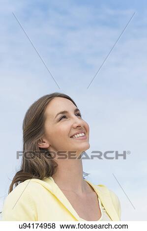 Portrait of beautiful young woman against sky View Large Photo Image Stock Photo - Portrait of beautiful young woman against sky. Fotosearch