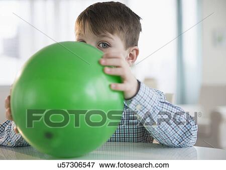 Stock Photo - Portrait of boy (4-5) blowing balloon. Fotosearch