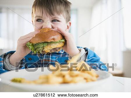 Portrait of boy (4-5) eating hamburger View Large Photo Image Stock Image - Portrait of boy (4-5) eating hamburger. Fotosearch