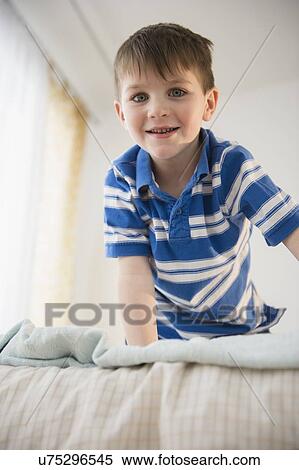 Portrait of boy (4-5) on bed View Large Photo Image Stock Photography - Portrait of boy (4-5) on bed. Fotosearch