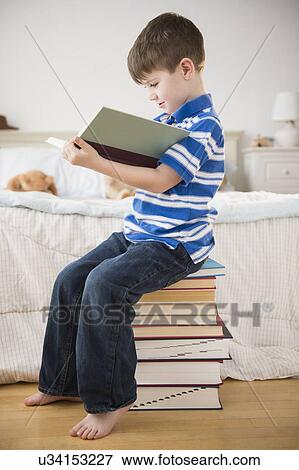 Portrait of boy (4-5) reading book View Large Photo Image Stock Photo - Portrait of boy (4-5) reading book. Fotosearch