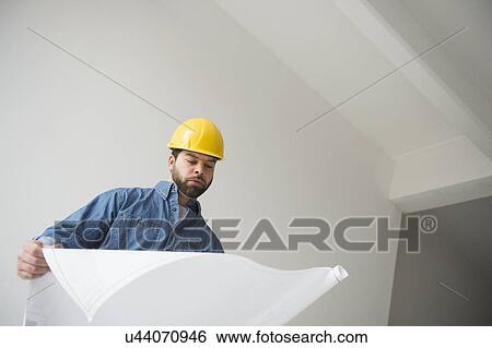 Portrait of construction worker looking at blueprints View Large Photo Image Stock Photograph - Portrait of construction worker looking at blueprints. Fotosearch