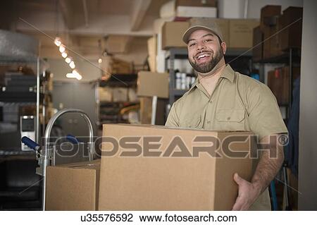 Stock Image - Portrait of delivery man in warehouse. Fotosearch