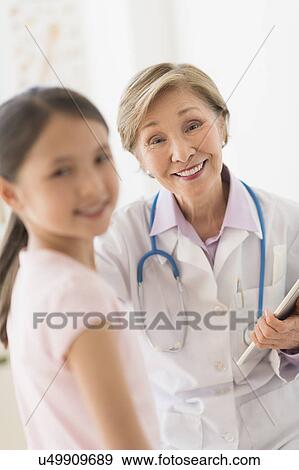 Portrait of doctor and girl (8-9) in foreground View Large Photo Image Stock Photo - Portrait of doctor and girl (8-9) in foreground. Fotosearch