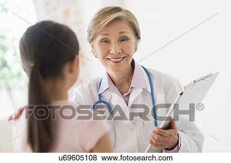 Portrait of doctor and girl (8-9) in foreground View Large Photo Image Stock Photo - Portrait of doctor and girl (8-9) in foreground. Fotosearch