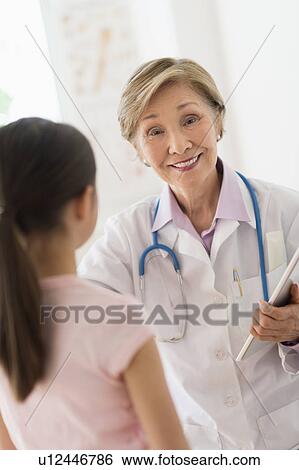 Portrait of doctor and girl (8-9) in foreground View Large Photo Image Stock Photograph - Portrait of doctor and girl (8-9) in foreground. Fotosearch