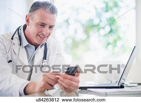 Portrait of doctor using mobile phone View Large Photo Image Stock Image - Portrait of doctor using mobile phone. Fotosearch