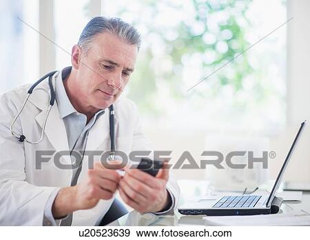 Portrait of doctor using mobile phone View Large Photo Image Stock Photo - Portrait of doctor using mobile phone. Fotosearch