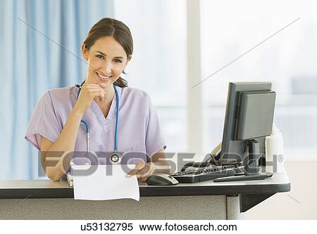 Portrait of female nurse at nurse's station in hospital View Large Photo Image Stock Photography - Portrait of female nurse at nurse's station in hospital. Fotosearch