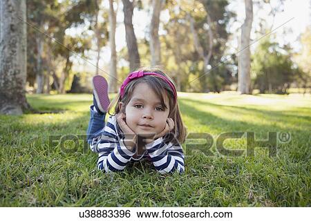 Portrait of girl (4-5 years) lying on grass in park View Large Photo Image Stock Photograph - Portrait of girl (4-5 years) lying on grass in park. Fotosearch