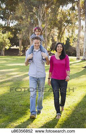 Stock Image - Portrait of happy family in park. Fotosearch