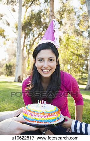 Stock Photo - Portrait of happy family in park celebrating mother's birthday. Fotosearch